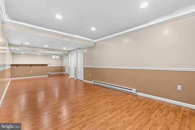 unfurnished living room featuring light wood-type flooring, ornamental molding, and baseboard heating