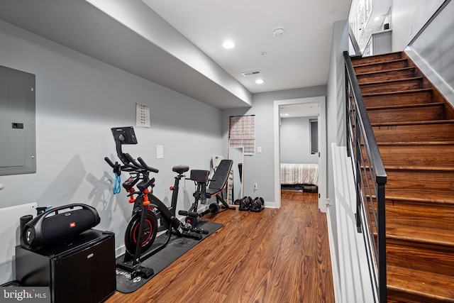 workout room featuring hardwood / wood-style flooring and electric panel