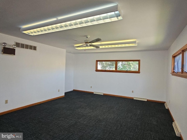 unfurnished room featuring visible vents, dark carpet, baseboards, and ceiling fan