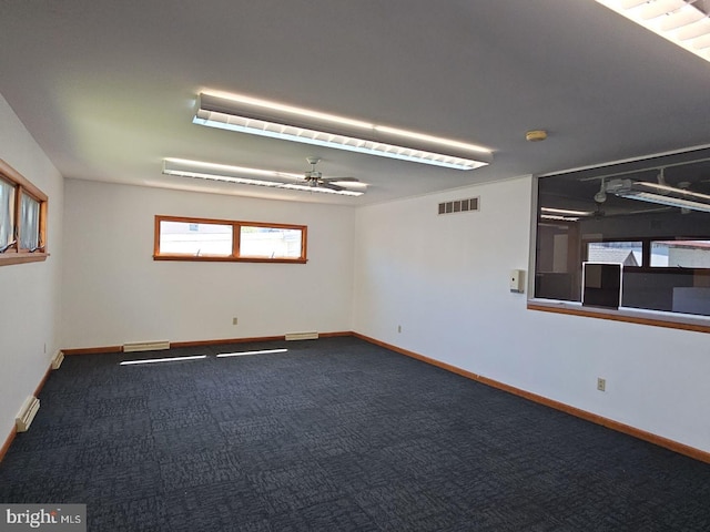 carpeted empty room with visible vents, ceiling fan, and baseboards