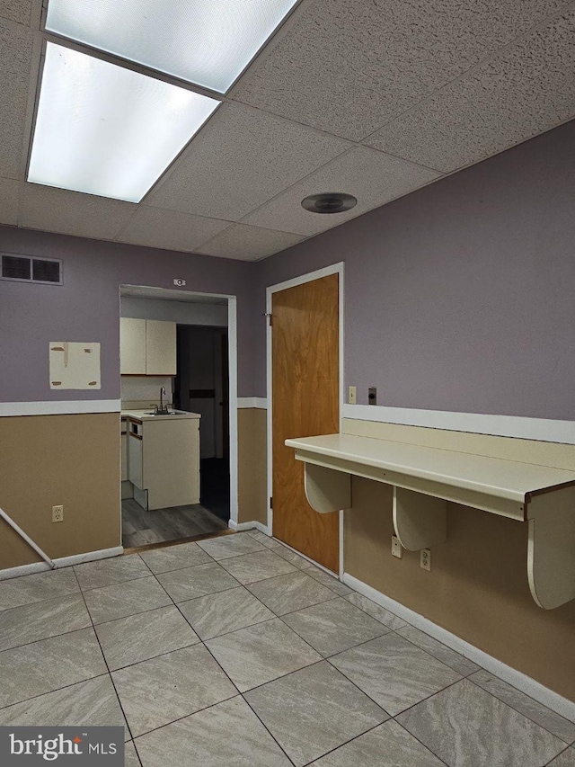 laundry area with sink, cabinets, and light tile patterned flooring