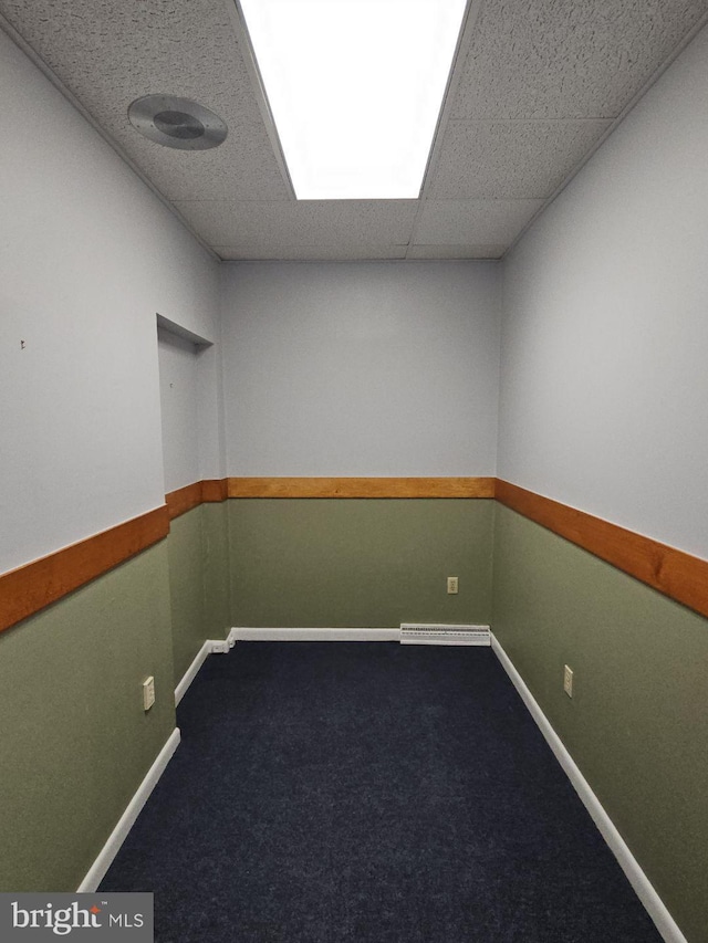 carpeted empty room featuring a paneled ceiling