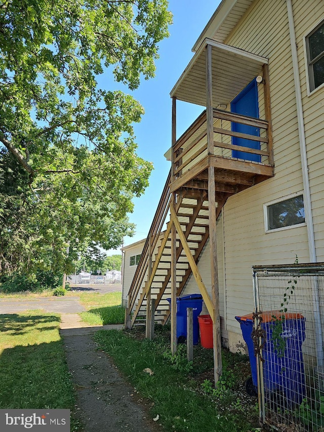 view of side of home with stairs and a balcony