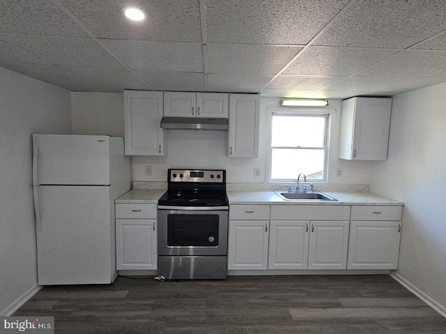 kitchen with stainless steel range with electric stovetop, light countertops, a sink, and freestanding refrigerator