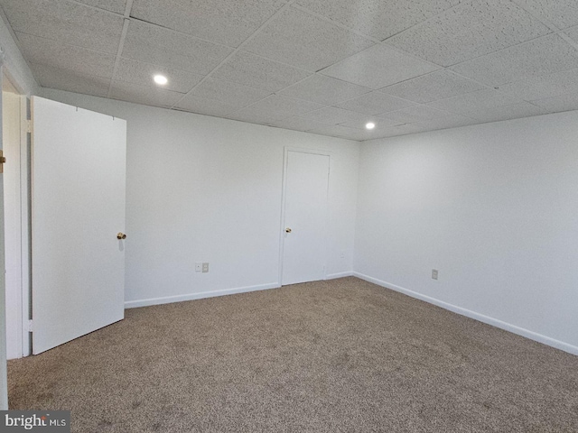 empty room with carpet, baseboards, a drop ceiling, and recessed lighting