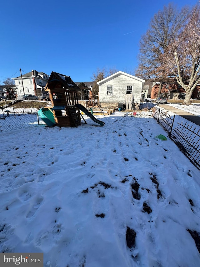 yard covered in snow with a playground