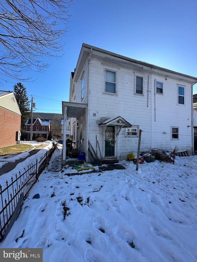 view of snow covered back of property