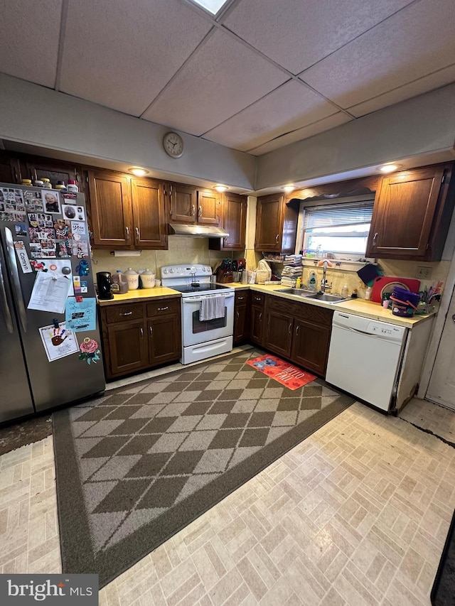 kitchen with sink, a drop ceiling, and white appliances