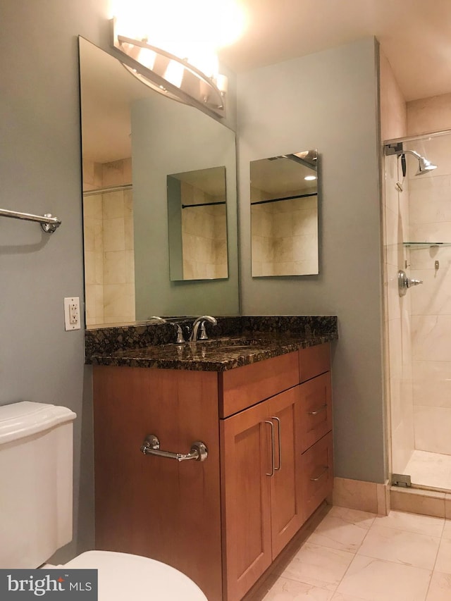 bathroom with toilet, marble finish floor, a shower stall, and vanity