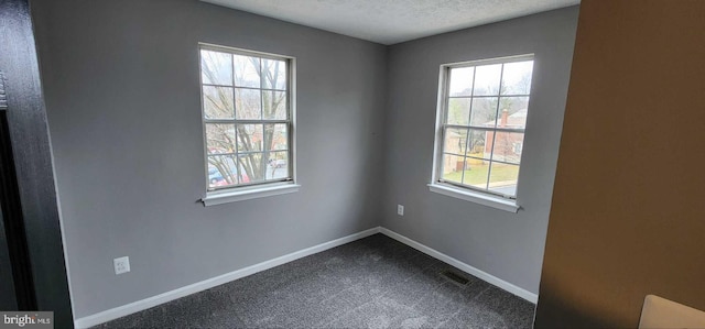 carpeted spare room with a textured ceiling