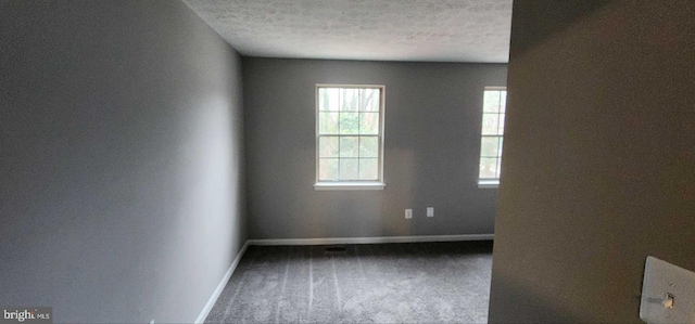 carpeted spare room with a textured ceiling