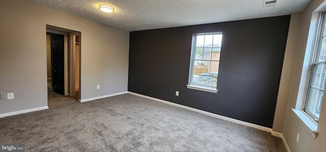 carpeted empty room with a textured ceiling