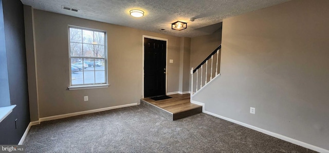 carpeted entrance foyer with a textured ceiling