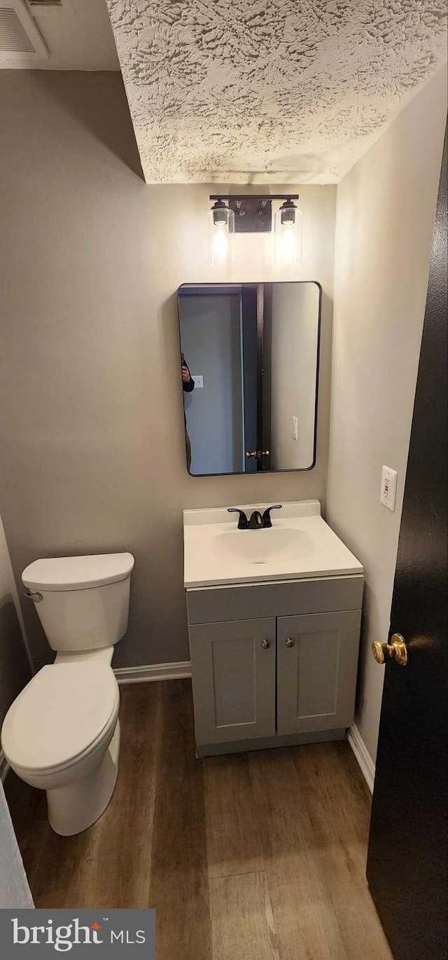 bathroom featuring vanity, hardwood / wood-style floors, and toilet