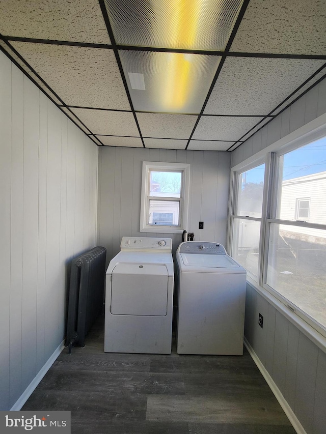 laundry room with washer and dryer, radiator, and dark hardwood / wood-style floors