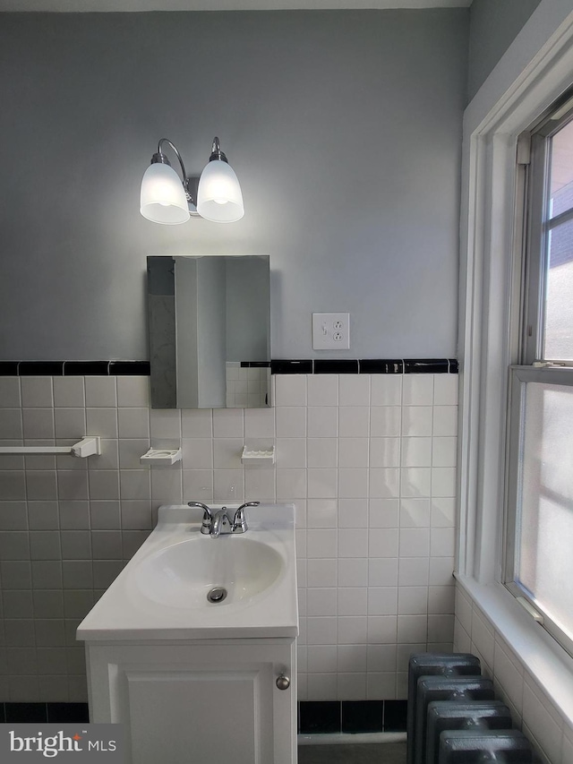 bathroom with vanity and tile walls