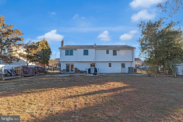 rear view of property featuring a yard and central AC