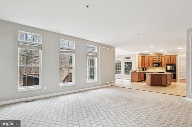 unfurnished living room with light carpet, visible vents, baseboards, and recessed lighting