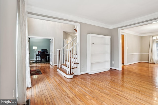 entryway featuring visible vents, ornamental molding, wood finished floors, baseboards, and stairs