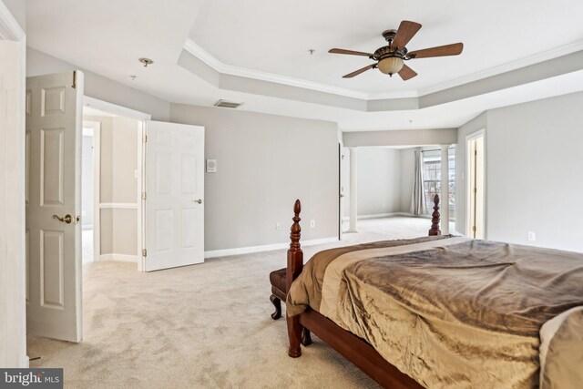 bedroom featuring crown molding, baseboards, a raised ceiling, and light colored carpet