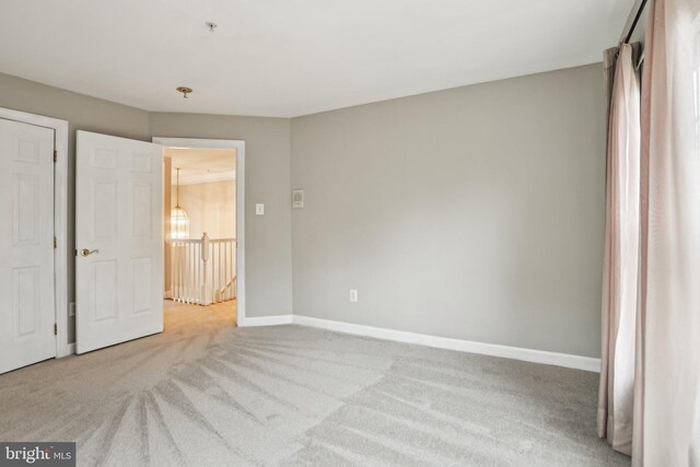 unfurnished bedroom featuring light carpet and baseboards