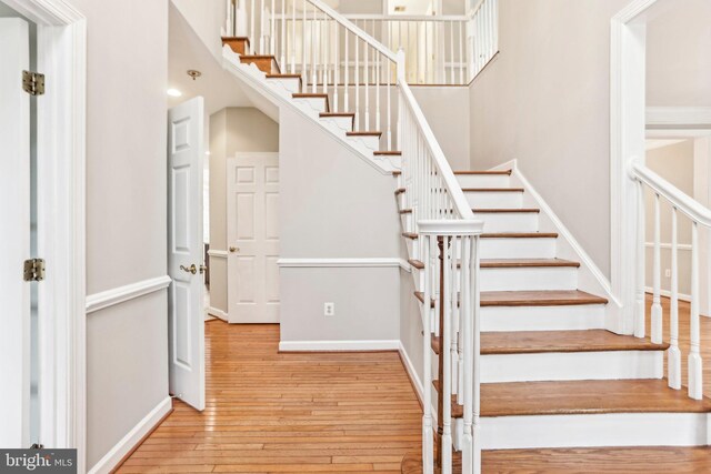 staircase featuring wood finished floors and baseboards