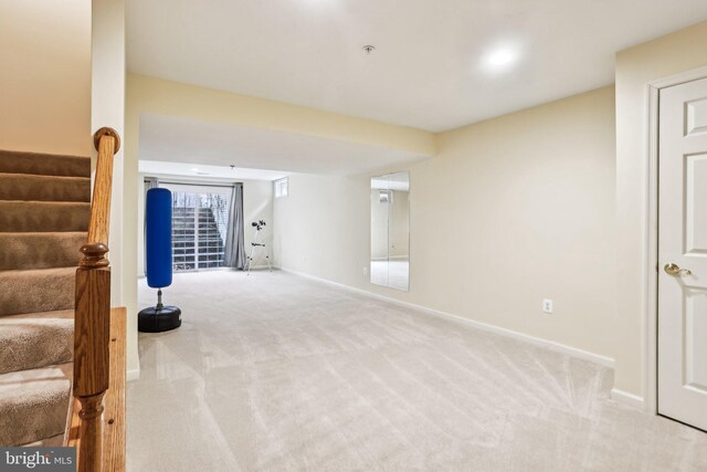 interior space featuring stairs, baseboards, and light colored carpet