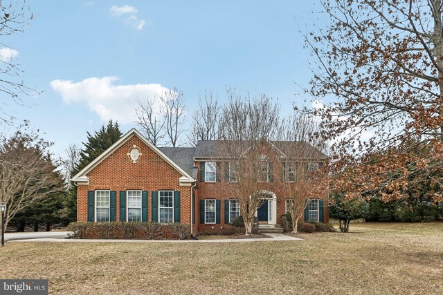 view of front facade with a front yard and brick siding