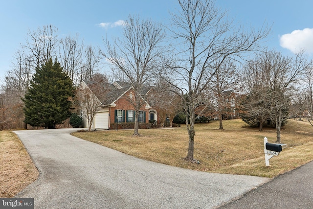 view of front facade featuring driveway, an attached garage, a front lawn, and brick siding