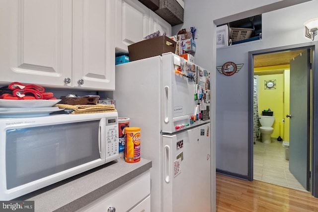 1010 Race St Unit 5D, Philadelphia, PA 19107 - kitchen with white cabinets, white appliances, and light hardwood / wood-style floors