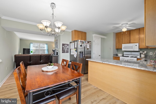 dining space with light wood-type flooring, crown molding, baseboards, and ceiling fan with notable chandelier