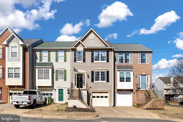 view of property featuring concrete driveway, stairway, and an attached garage