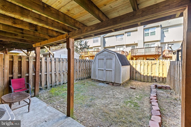 view of yard with a fenced backyard, an outdoor structure, and a storage unit