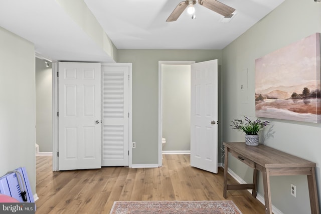 bedroom with ceiling fan, wood finished floors, visible vents, and baseboards