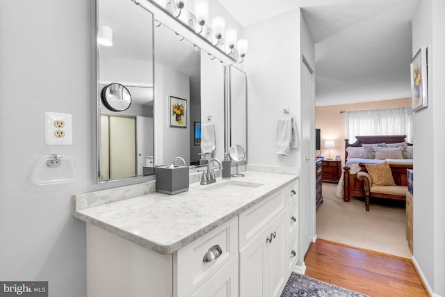 bathroom featuring vanity, hardwood / wood-style flooring, and a textured ceiling