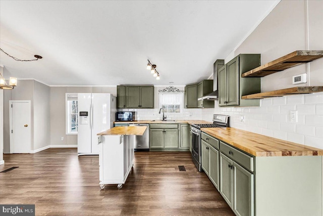 kitchen with stainless steel appliances, a sink, wooden counters, open shelves, and green cabinetry