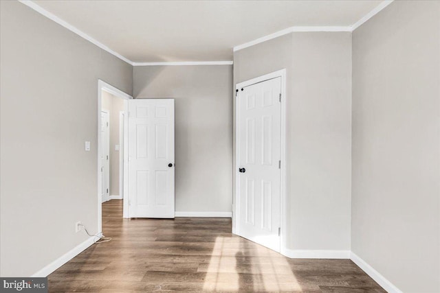 unfurnished bedroom with crown molding, baseboards, and wood finished floors