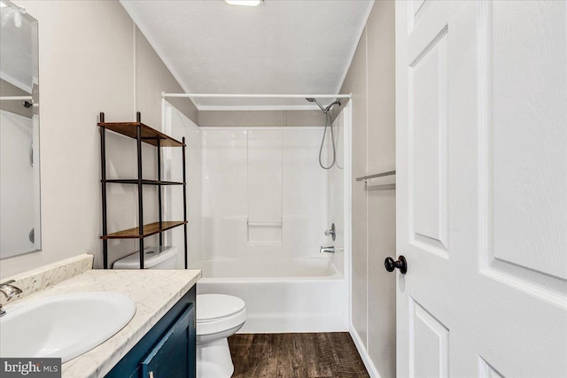 full bathroom featuring toilet, wood finished floors, a textured ceiling, vanity, and washtub / shower combination