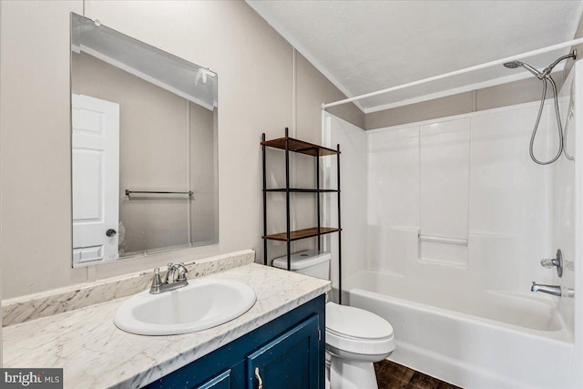 bathroom with toilet, a textured ceiling, vanity, wood finished floors, and  shower combination