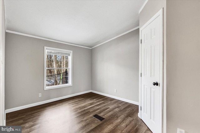 unfurnished bedroom with dark wood finished floors, visible vents, and baseboards