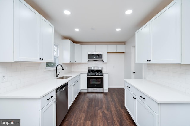 kitchen with white cabinetry, appliances with stainless steel finishes, dark hardwood / wood-style floors, and sink