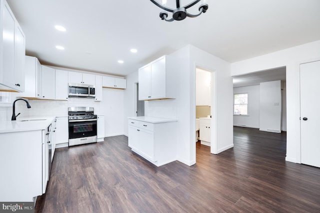 kitchen with dark wood-type flooring, sink, white cabinetry, tasteful backsplash, and stainless steel appliances