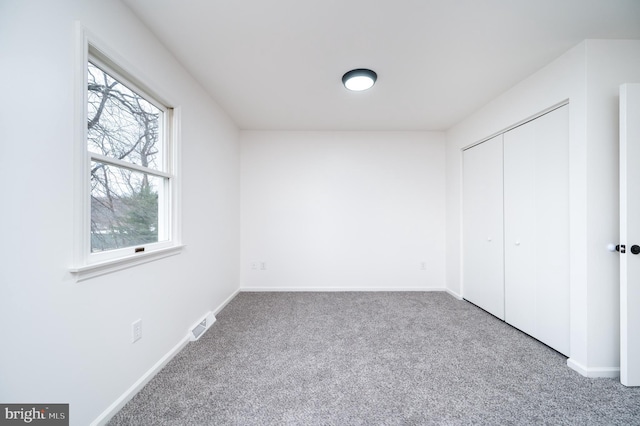 unfurnished bedroom with carpet flooring and a closet