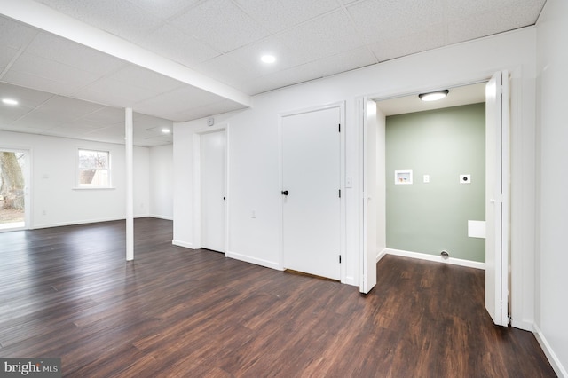 basement featuring a drop ceiling and dark hardwood / wood-style floors