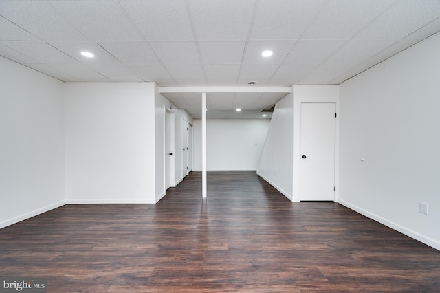 basement with dark hardwood / wood-style flooring and a drop ceiling