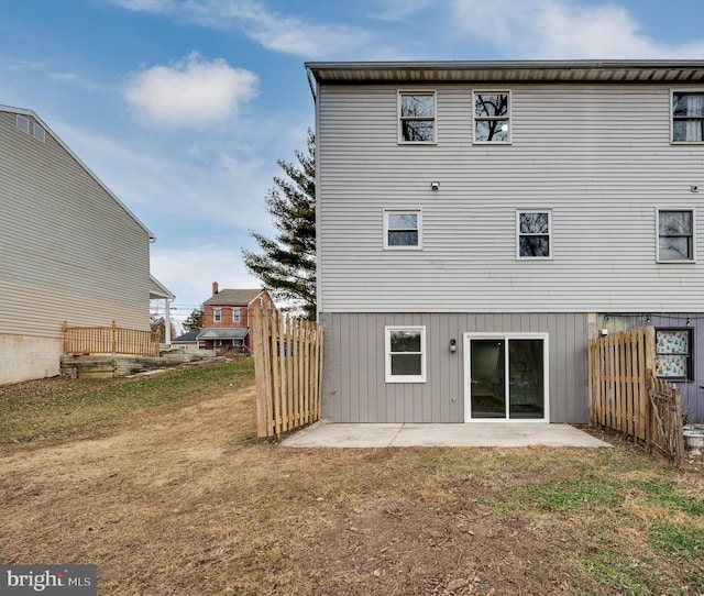 rear view of property with a patio and a lawn