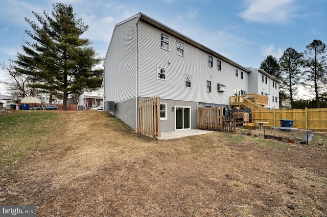 rear view of property featuring cooling unit and a yard