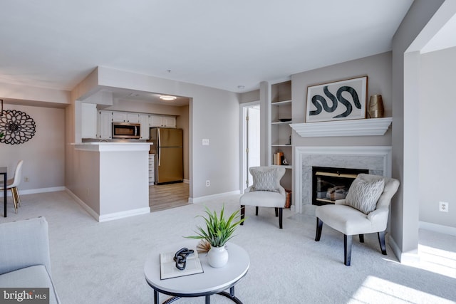 carpeted living room featuring a high end fireplace