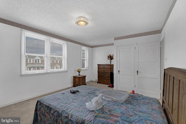 bedroom featuring light colored carpet and a textured ceiling