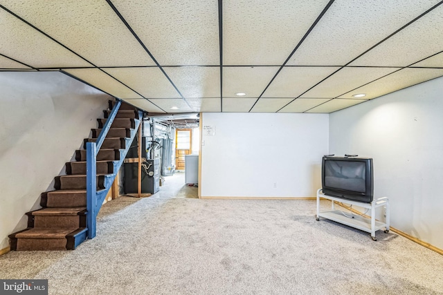 basement featuring a paneled ceiling and carpet flooring